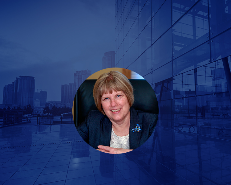 Photograph of buildings with a blue filter, featuring profile photo of Evelyn Gryk Frolich cropped in a circular shape without any filter placed in the center.